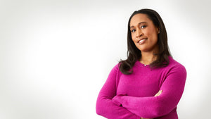 Nichole Wilson is wearing a bright pink sweater against a white background